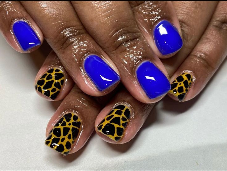 Animal print nail art featuring giraffe print and solid blue polish