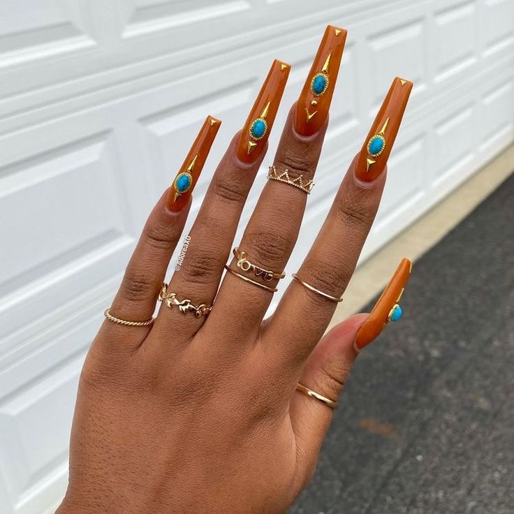 Gold acrylic nails with turquoise gemstones 